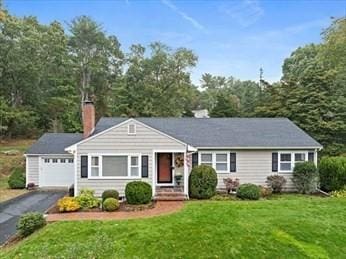 ranch-style home featuring a garage and a front lawn