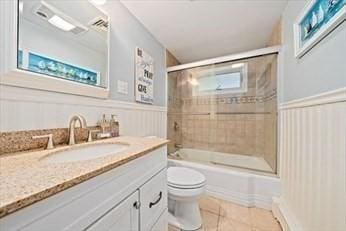 full bathroom featuring tile patterned flooring, vanity, enclosed tub / shower combo, and toilet