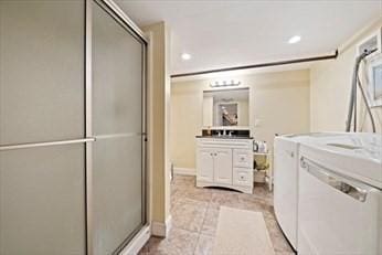 washroom with washing machine and clothes dryer and light tile patterned floors