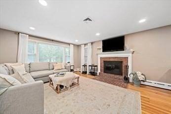 living room with light wood-type flooring and a baseboard radiator