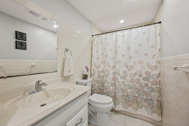 bathroom with tile walls, walk in shower, vanity, tile patterned flooring, and toilet