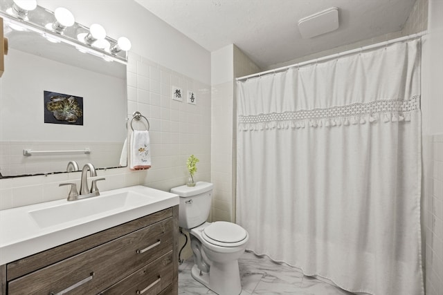 bathroom featuring curtained shower, vanity, toilet, and tile walls