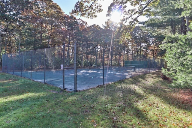 view of tennis court with a lawn