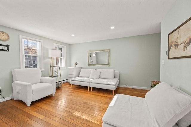 living room featuring a baseboard heating unit and light wood-type flooring