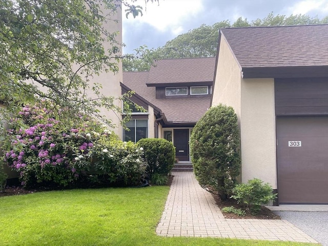 303 Goddard Ave Unit 303, Brookline, MA 02445 - view of front of house with roof with shingles, a front lawn, and stucco siding