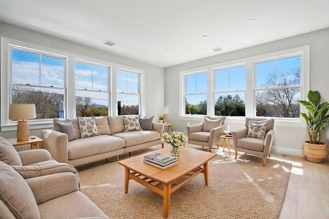 living area with visible vents, baseboards, and wood finished floors