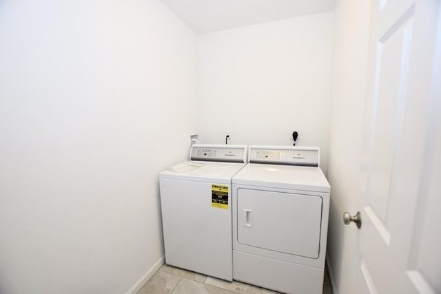 clothes washing area featuring washer and dryer and light tile patterned floors