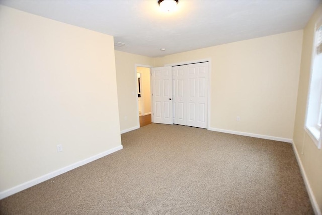 unfurnished bedroom with carpet flooring and a closet