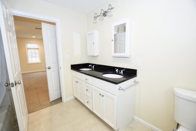 bathroom featuring toilet, vanity, and tile patterned floors