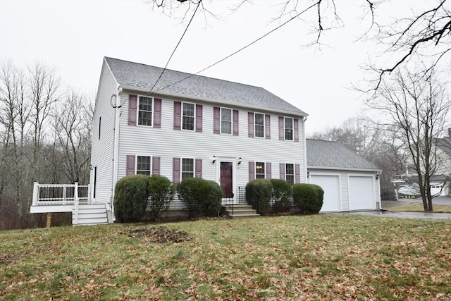 colonial house featuring a front yard and a garage