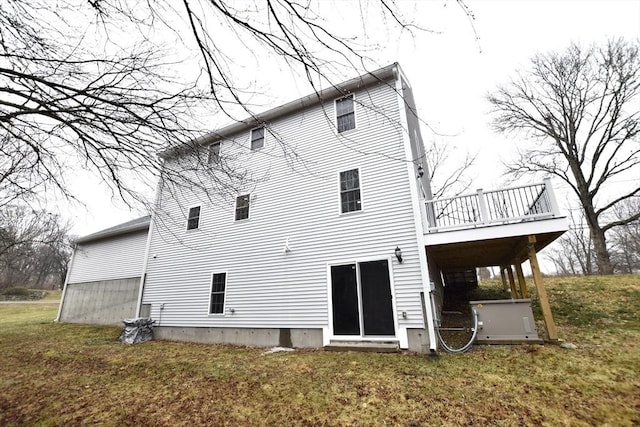 back of house featuring a lawn and a deck