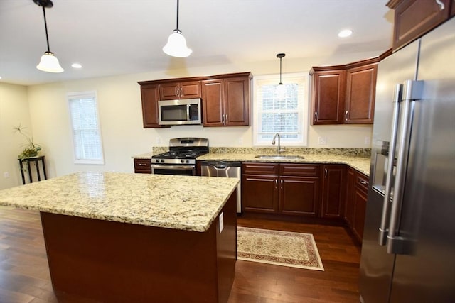 kitchen featuring pendant lighting, a center island, sink, and appliances with stainless steel finishes