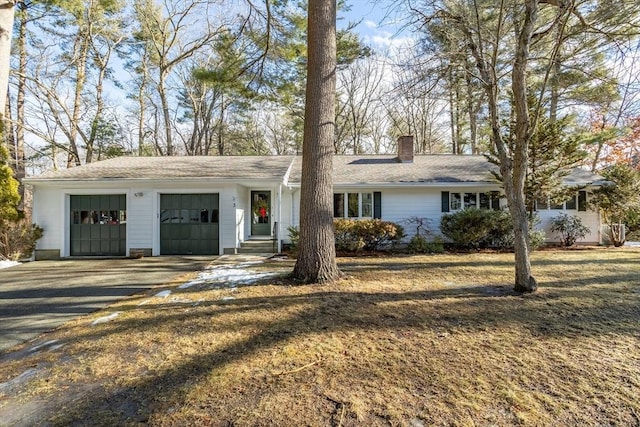 ranch-style home with a garage and a front lawn