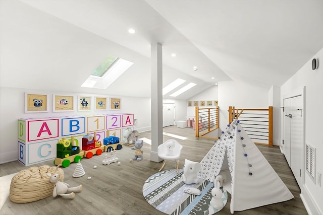 recreation room featuring dark hardwood / wood-style flooring and vaulted ceiling with skylight