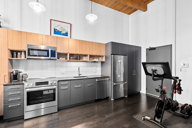 kitchen featuring wood ceiling, hanging light fixtures, beamed ceiling, dark wood-type flooring, and stainless steel appliances