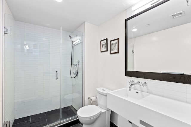 bathroom with toilet, tasteful backsplash, and walk in shower