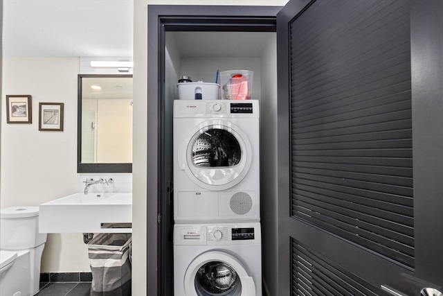 washroom with stacked washing maching and dryer, sink, and tile patterned floors