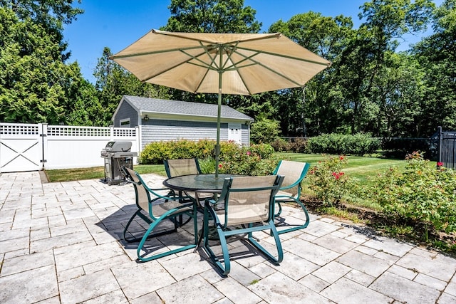 view of patio with an outdoor structure and a grill