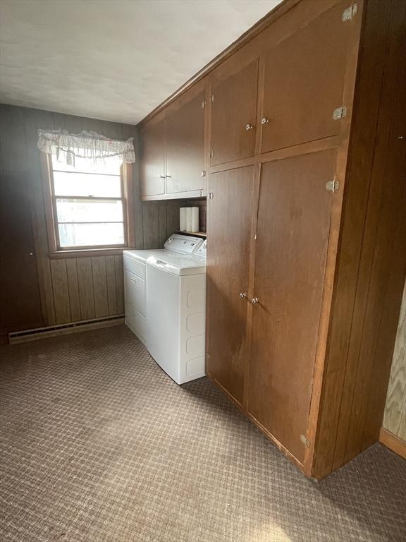 washroom with separate washer and dryer, light carpet, cabinets, and wood walls