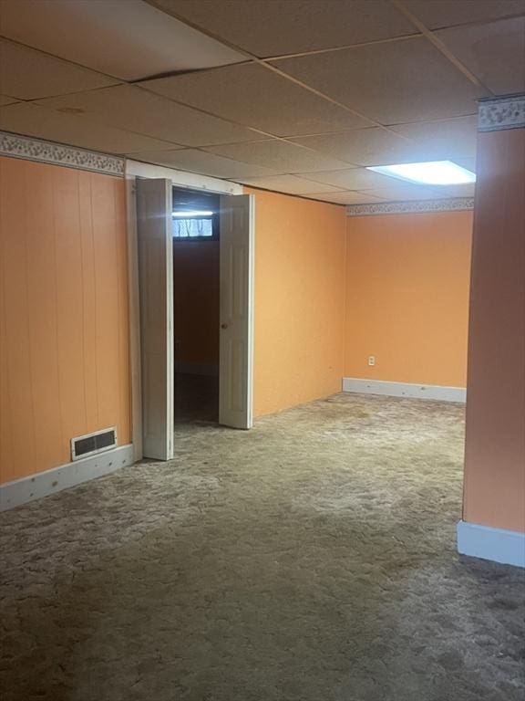 basement with carpet floors and a paneled ceiling