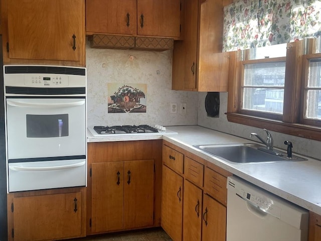 kitchen with sink, white appliances, and backsplash