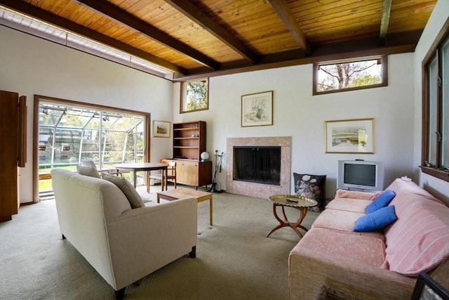 carpeted living room featuring a premium fireplace, wooden ceiling, and beam ceiling