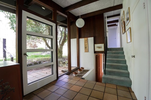 doorway featuring stairway and beamed ceiling
