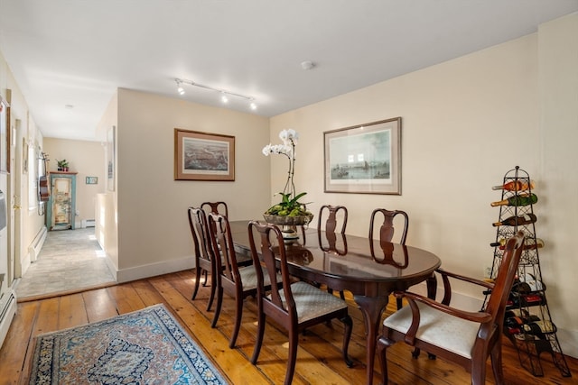 dining space featuring light wood-type flooring and a baseboard heating unit