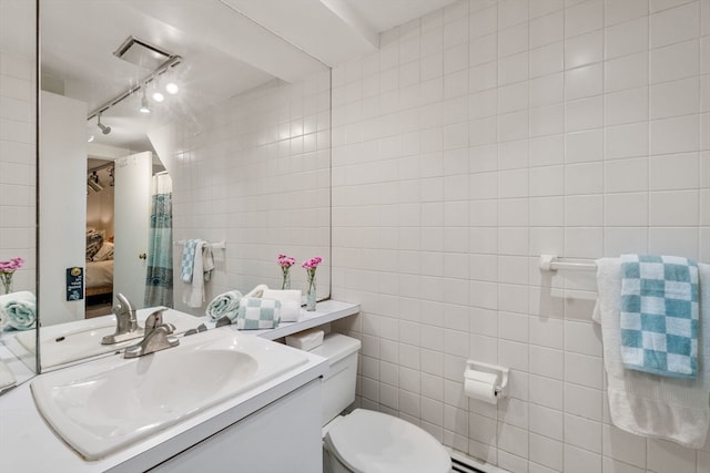 bathroom with vanity, tile walls, toilet, and rail lighting