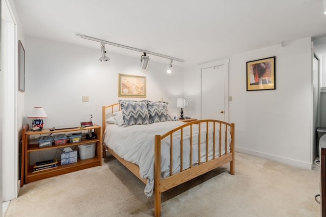 carpeted bedroom featuring rail lighting