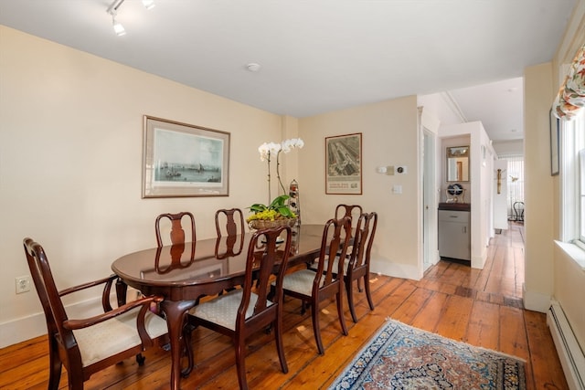 dining area with hardwood / wood-style floors and a baseboard radiator