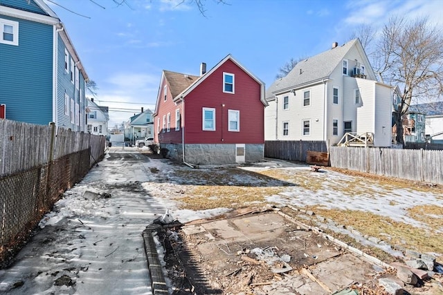 rear view of house featuring a residential view and fence