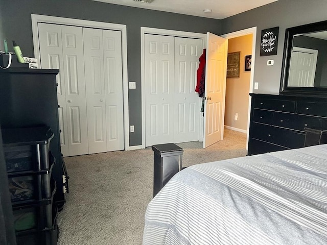 carpeted bedroom featuring multiple closets