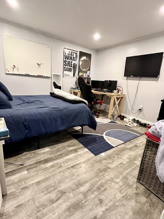 bedroom featuring wood-type flooring and basketball hoop