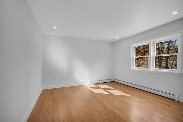 spare room with a baseboard radiator and light hardwood / wood-style flooring