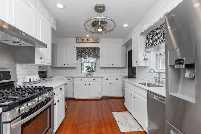 94 Circuit Rd, Winthrop, MA 02152 - kitchen with appliances with stainless steel finishes, ventilation hood, light countertops, white cabinetry, and tasteful backsplash