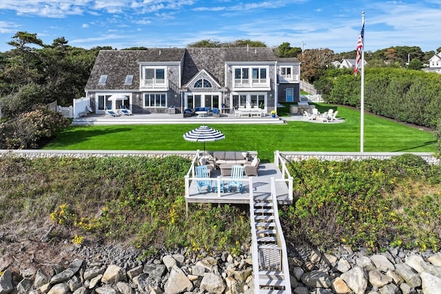 rear view of house with outdoor lounge area, a patio area, and a yard