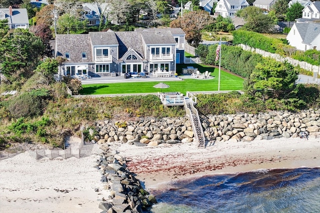 rear view of property featuring a lawn and a water view