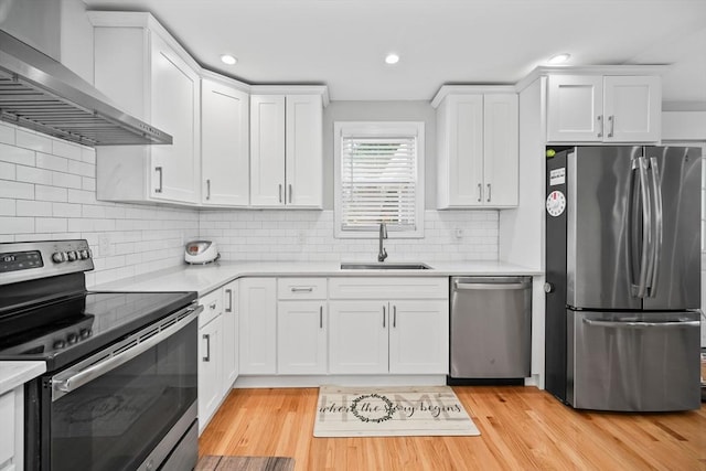 8 Nicholl St, Quincy, MA 02169 - kitchen featuring stainless steel appliances, wall chimney range hood, light countertops, white cabinets, and light wood-style floors
