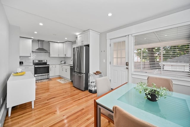 8 Nicholl St, Quincy, MA 02169 - kitchen featuring appliances with stainless steel finishes, wall chimney range hood, tasteful backsplash, light countertops, and light wood finished floors