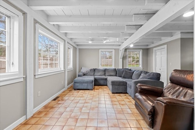 living room featuring light tile patterned floors, baseboards, and beam ceiling