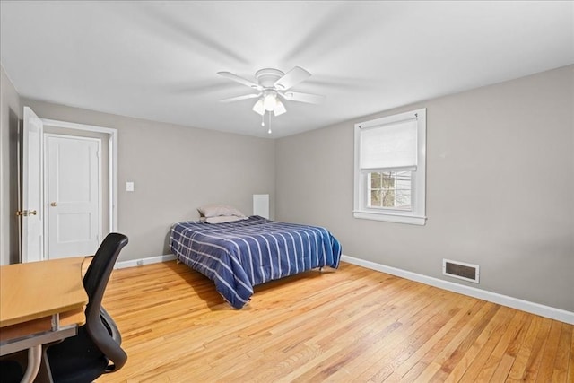 bedroom featuring wood-type flooring, visible vents, baseboards, and a ceiling fan