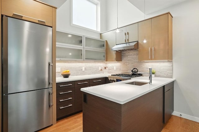 95 Kirkland St Unit 95, Cambridge, MA 02138 - kitchen featuring freestanding refrigerator, under cabinet range hood, a peninsula, and light wood finished floors