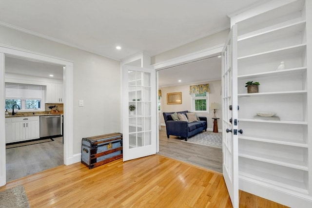 98 Haseltine St, Haverhill, MA 01835 - hall featuring french doors, light wood finished floors, crown molding, a sink, and recessed lighting