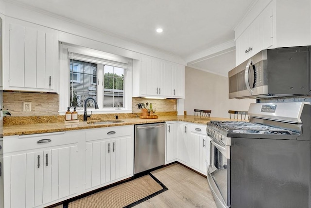 98 Haseltine St, Haverhill, MA 01835 - kitchen with stainless steel appliances, a sink, ornamental molding, light wood-style floors, and backsplash