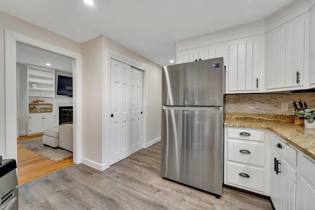 98 Haseltine St, Haverhill, MA 01835 - kitchen featuring freestanding refrigerator, light wood finished floors, tasteful backsplash, white cabinetry, and recessed lighting