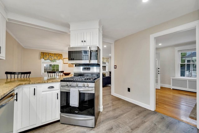98 Haseltine St, Haverhill, MA 01835 - kitchen with appliances with stainless steel finishes, radiator heating unit, light wood finished floors, healthy amount of natural light, and recessed lighting