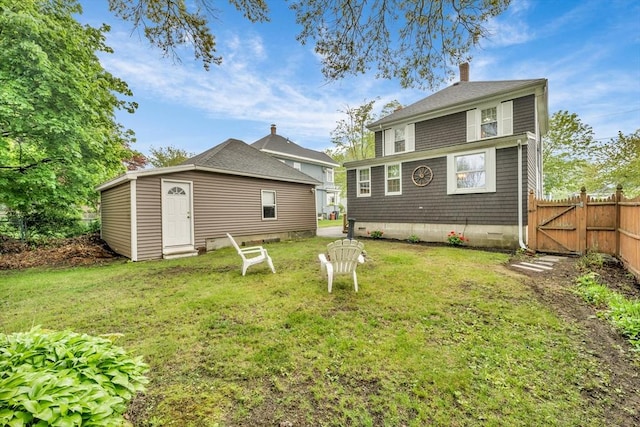 98 Haseltine St, Haverhill, MA 01835 - rear view of house with a chimney, an outbuilding, and a gate