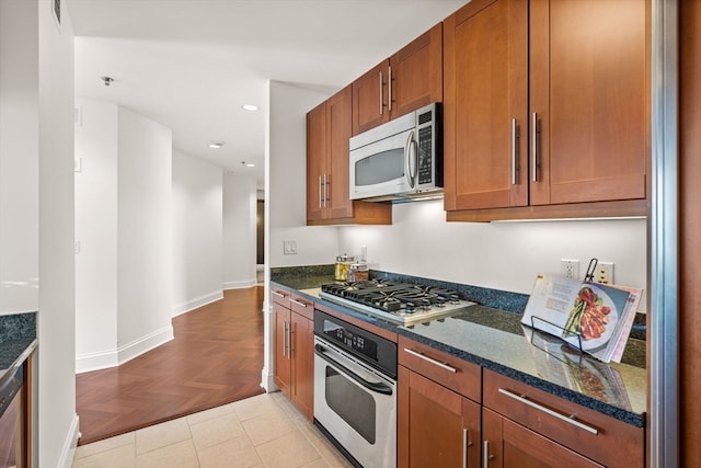 kitchen featuring dark stone counters, light parquet floors, and stainless steel appliances