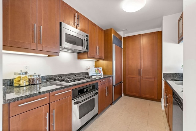 kitchen featuring appliances with stainless steel finishes and dark stone counters